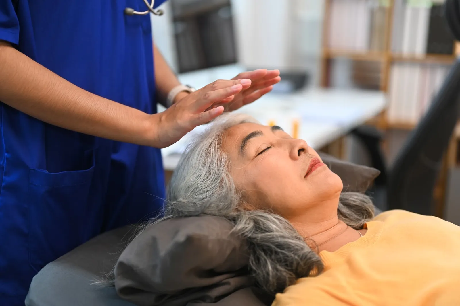Maestra de Reiki proporcionando sanación energética a su cliente